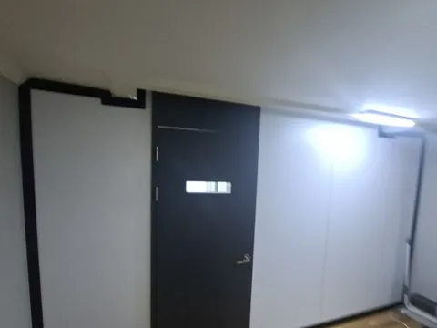 석고보드시공 상담 안내: 흰색 가벽과 문이 있는 방 내부 사진 예시