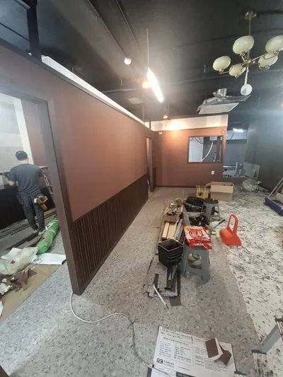 템바보드시공으로 하단을 마감한 갈색 가벽과 작업 공구가 놓인 룸